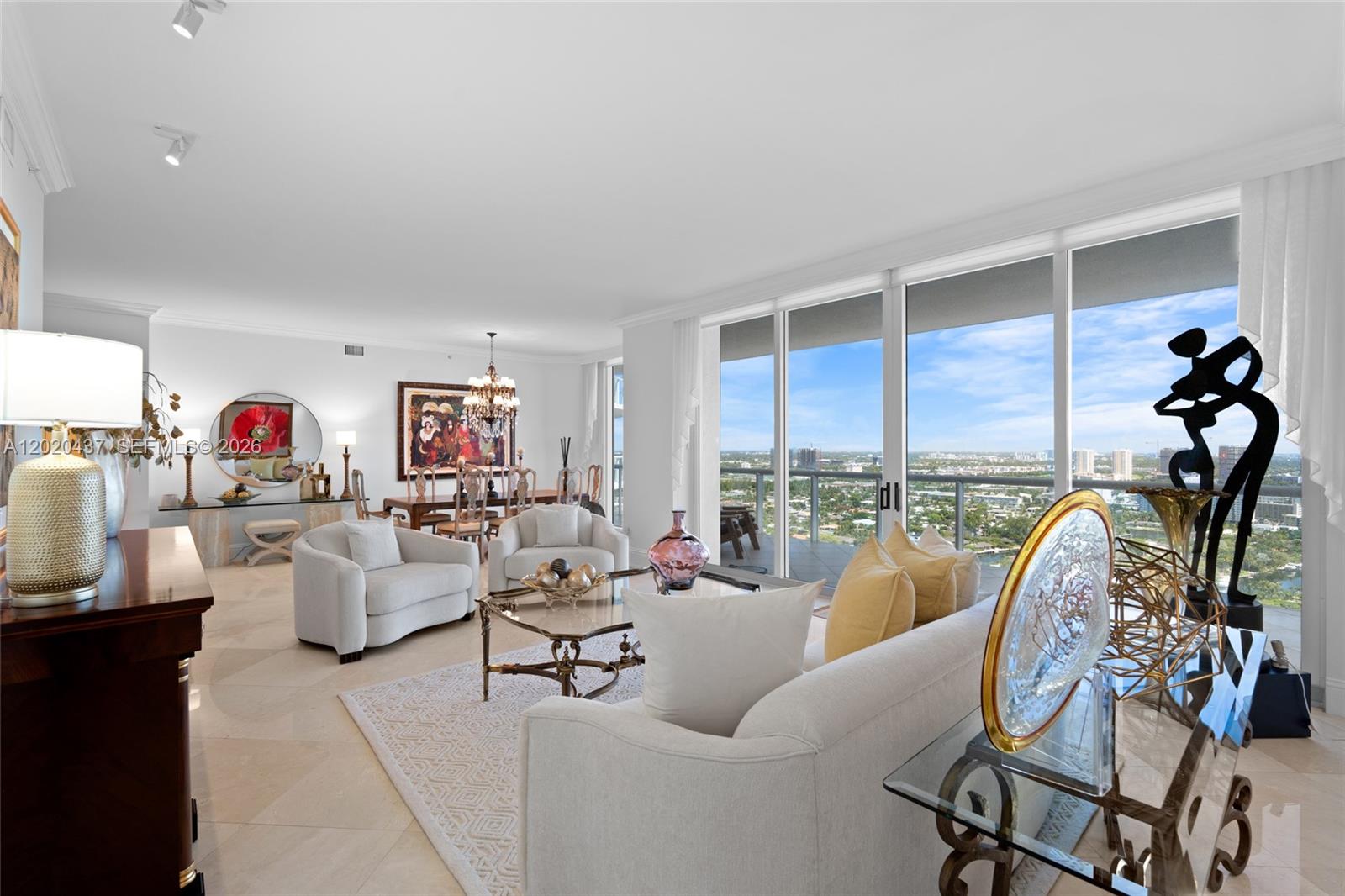 A bright living and dining area features tile floors, floor-to-ceiling windows, and a balcony view — 21200 Point Pl # 2802, Aventura FL 33180, AVENTURA, FL
