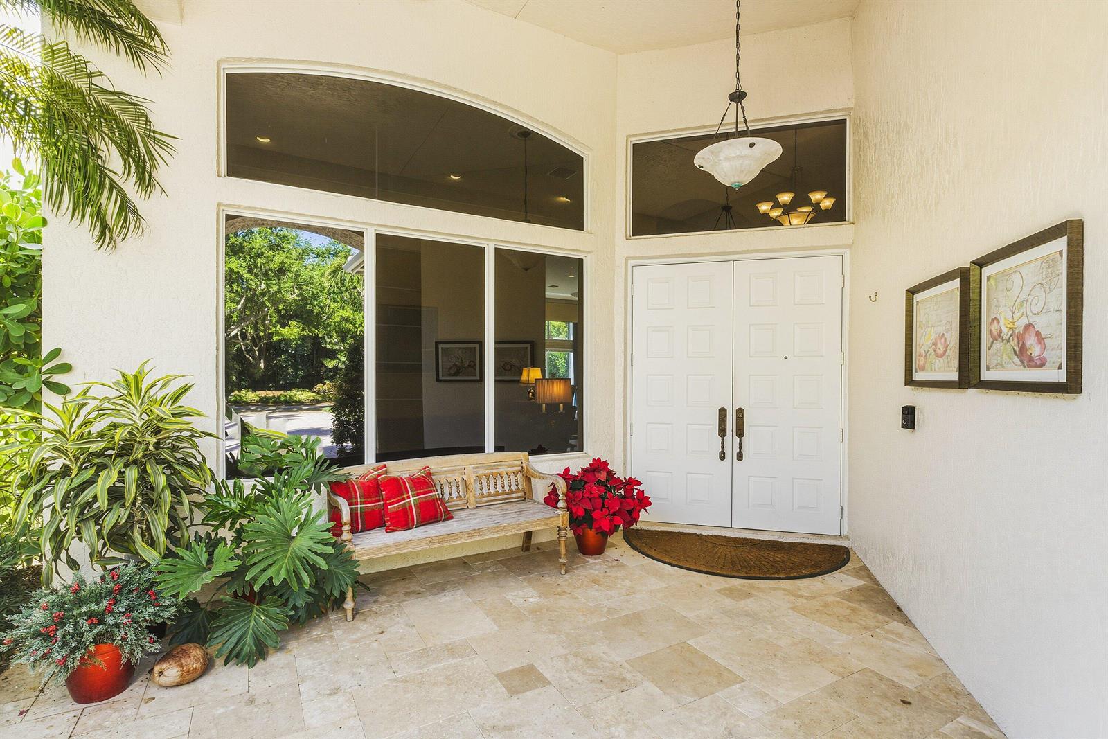 A swimming pool and spa sit beside a house with a screened-in patio area — 7011 Islegrove Place, Boca Raton FL 33433, BOCA RATON, FL