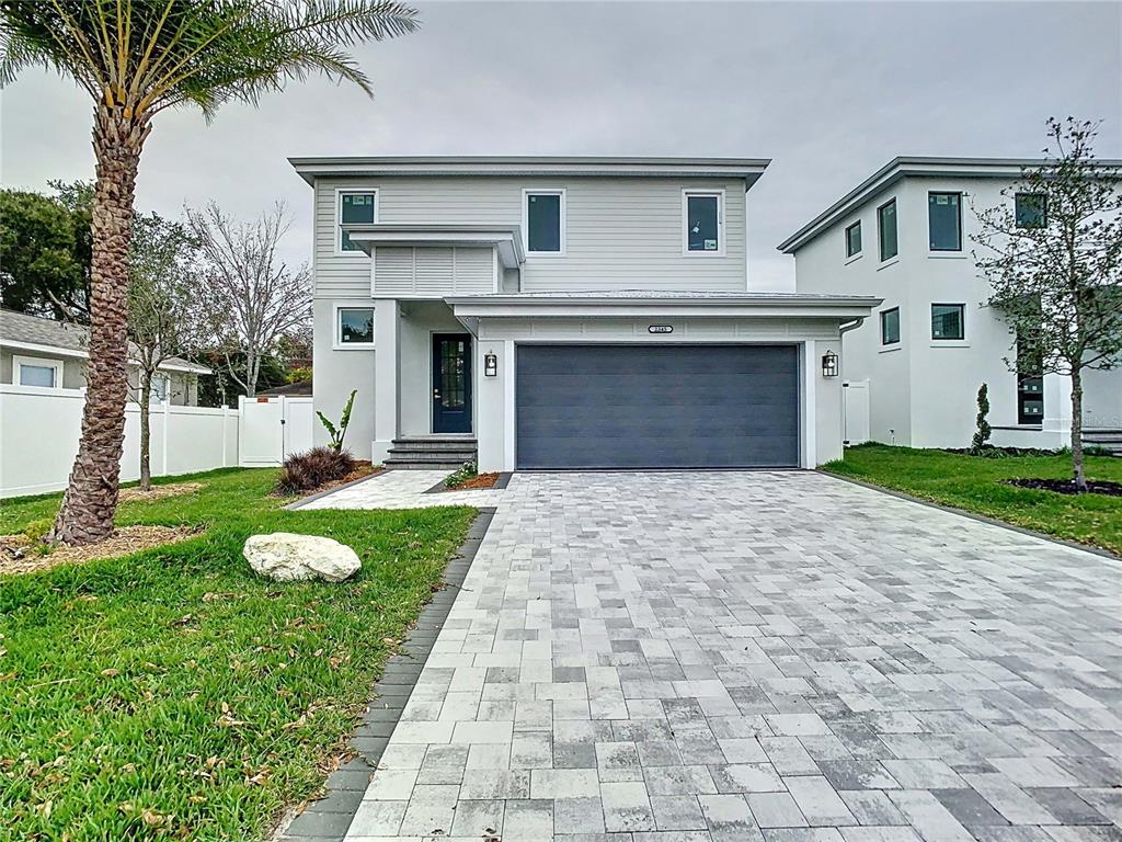 A two-story house with light gray siding, a dark garage door, and a paved driveway — 2345 BAHIA VISTA STREET, SARASOTA, FL