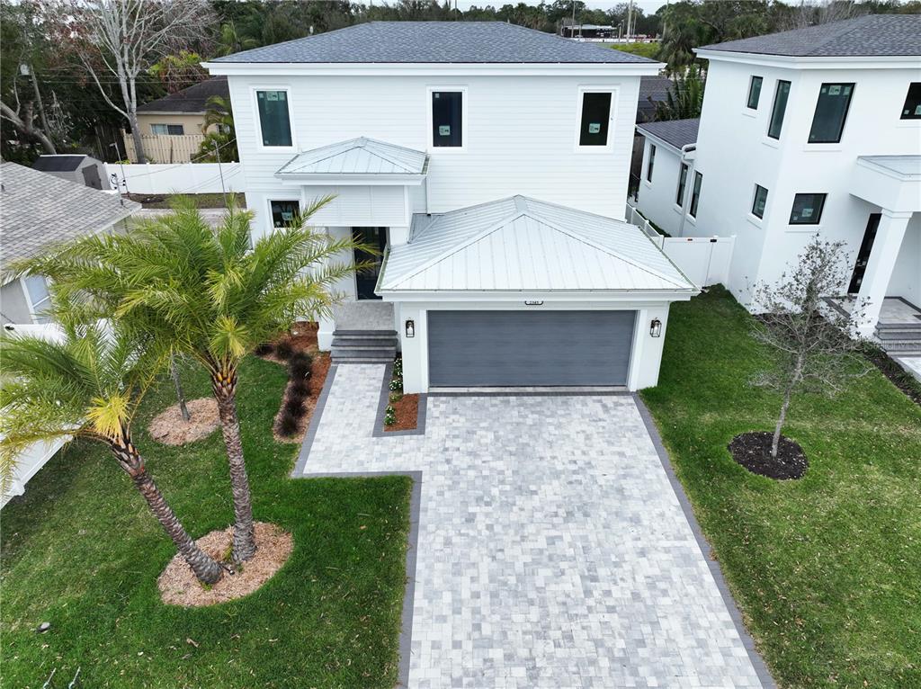 An aerial view of a two-story white house with a metal roof and paver driveway — 2345 BAHIA VISTA STREET, SARASOTA, FL