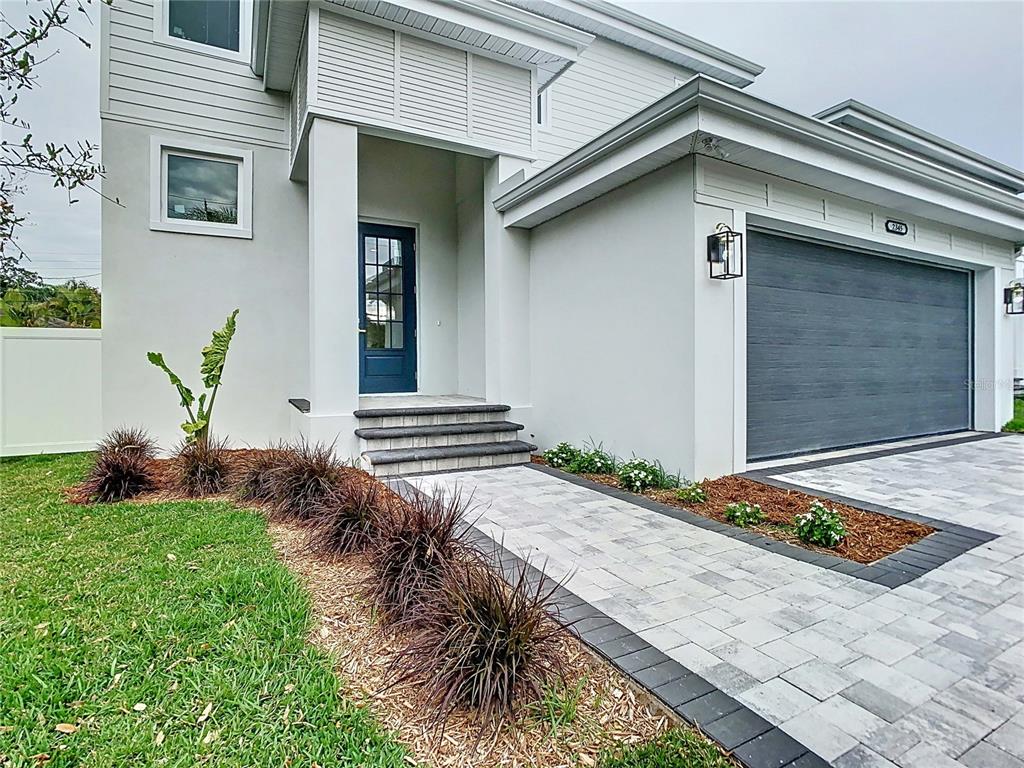 A modern house exterior features a blue front door, stone steps, and a paved walkway — 2345 BAHIA VISTA STREET, SARASOTA, FL