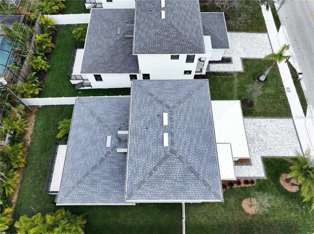 An aerial view shows the gray shingled roofs of two adjacent houses with paved driveways — 2345 BAHIA VISTA STREET, SARASOTA, FL
