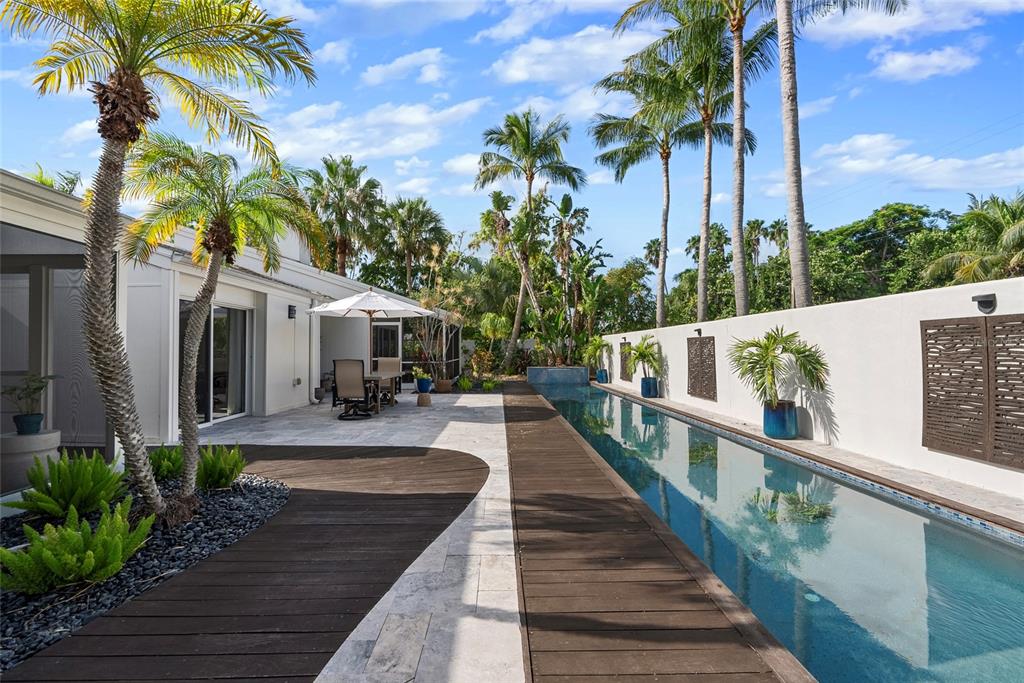 A narrow lap pool runs alongside a wooden deck and a white house exterior — 1100 WESTWAY DRIVE, SARASOTA, FL