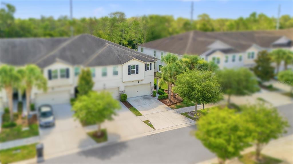 An aerial view shows two-story townhomes with attached garages and surrounding landscaping — 10316 HOLSTEIN EDGE PLACE, RIVERVIEW, FL