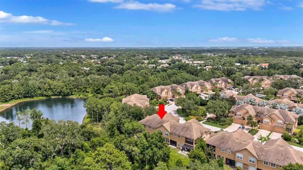 An aerial view shows a multi-story residential building with a red arrow pointing to it — 8228 VILLA GRANDE COURT, SARASOTA, FL
