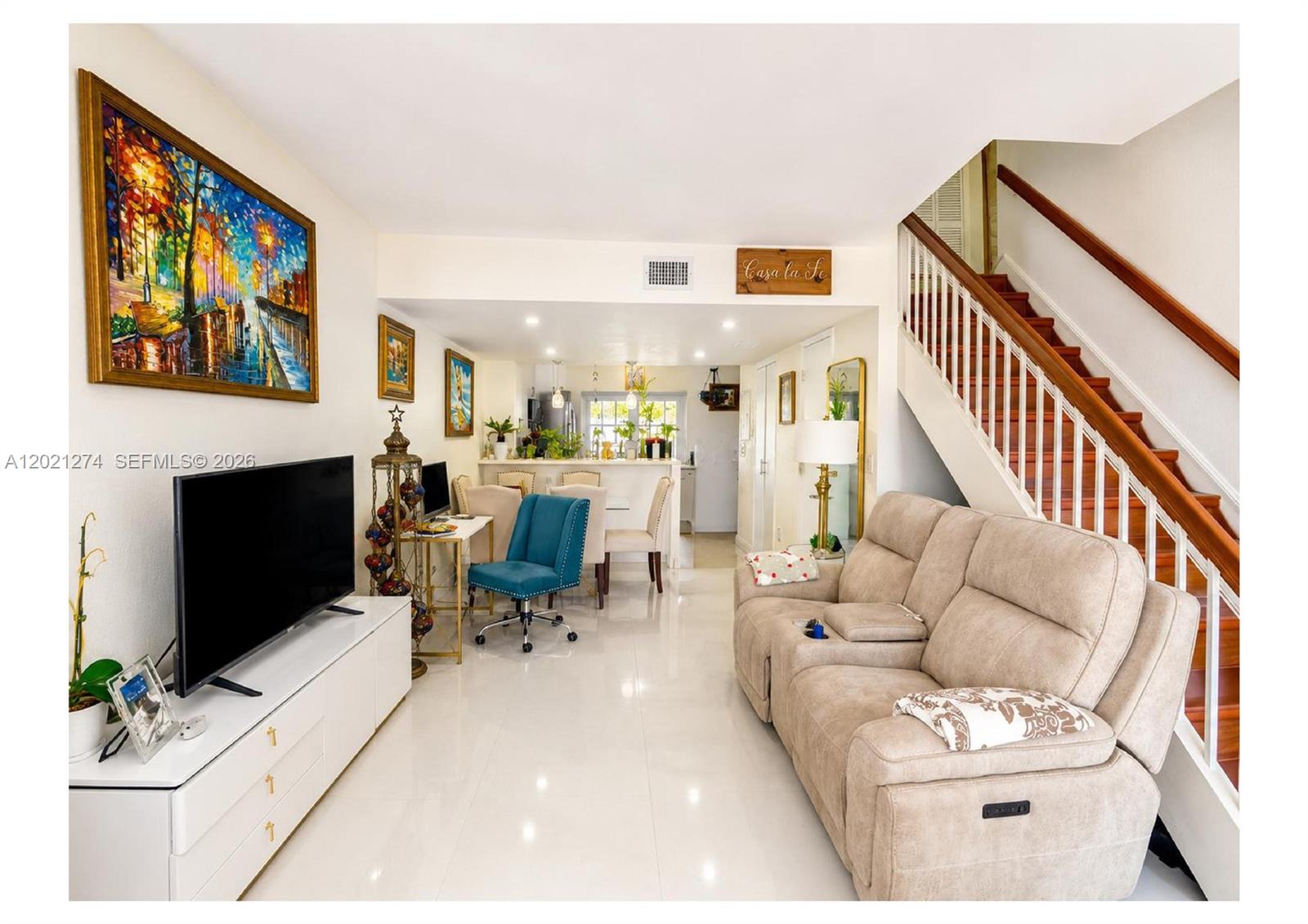 A living room features a beige reclining sofa, a white media console, and a staircase — 8265 NW 6th Ter # 251, Miami FL 33126, MIAMI, FL