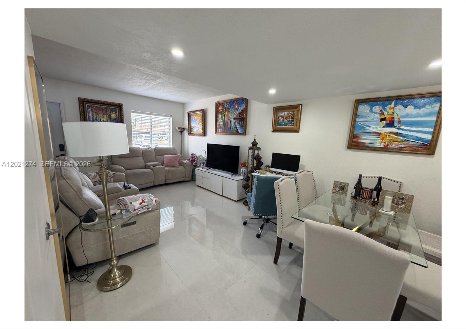 A living and dining area features light-colored tile floors, a sectional sofa, and wall art — 8265 NW 6th Ter # 251, Miami FL 33126, MIAMI, FL