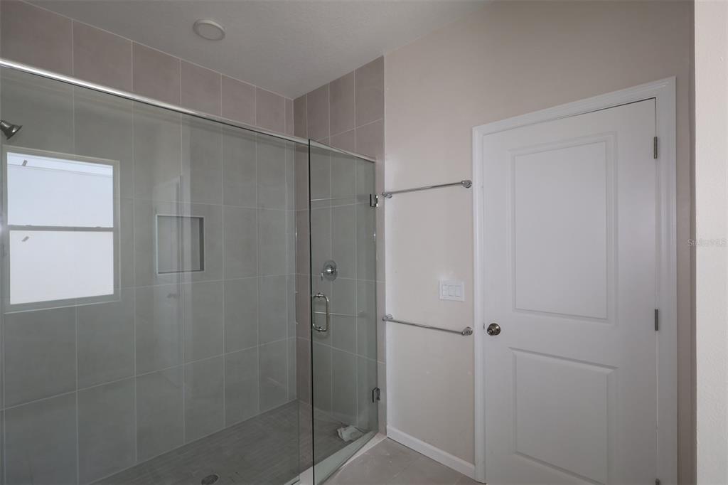 A kitchen with white cabinets, a central island, and wood-look tile flooring — 2679 GREAT HERON AVENUE, ST CLOUD, FL