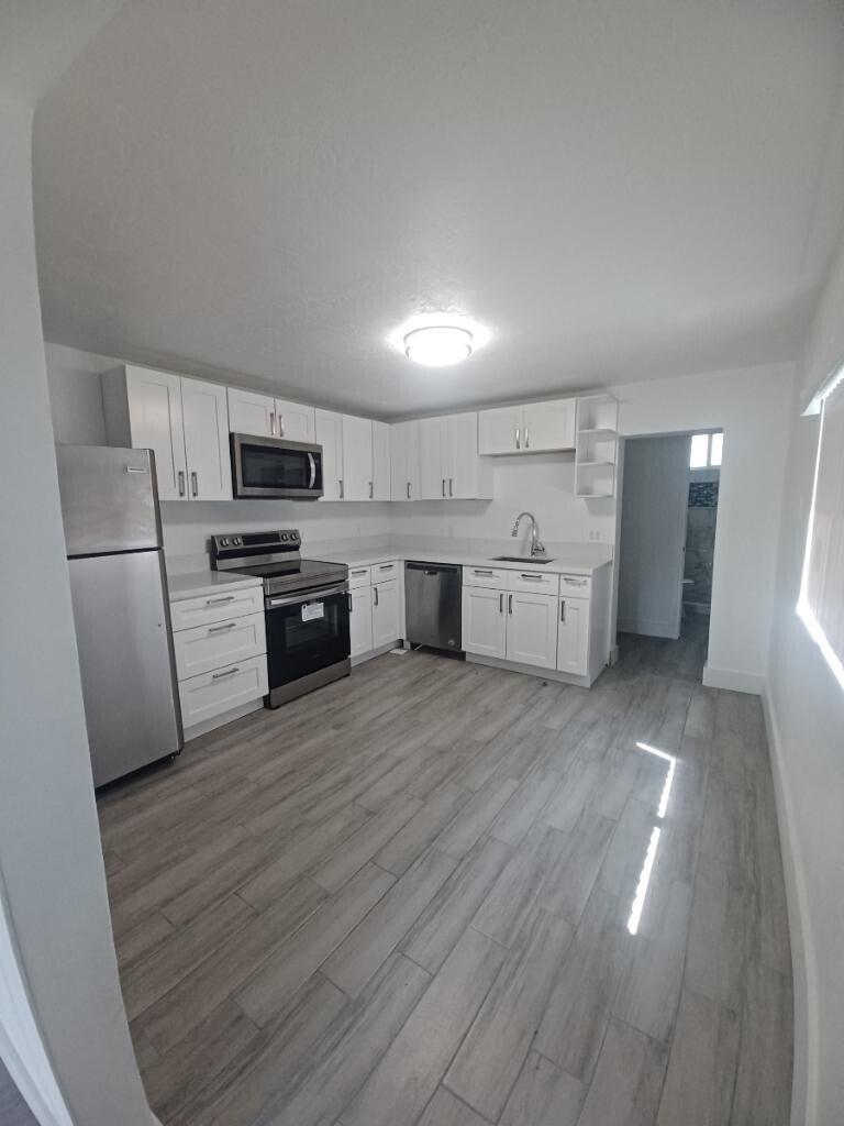 A kitchen with white cabinets, stainless steel appliances, and light wood-look flooring — 24 SW 13th Street # 5, Dania Beach FL 33004, DANIA BEACH, FL