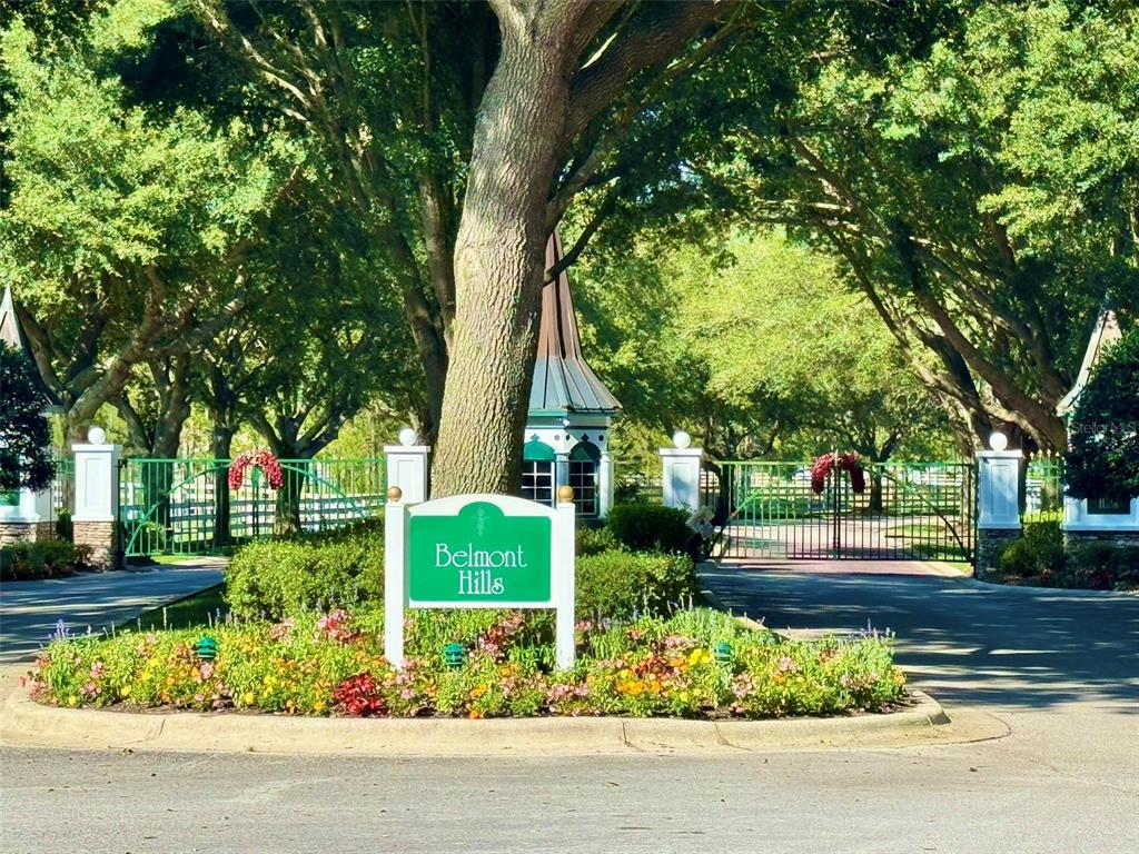 A green sign for Belmont Hills stands in front of a gated community entrance — 56 S NEEDLES POINT, INVERNESS, FL