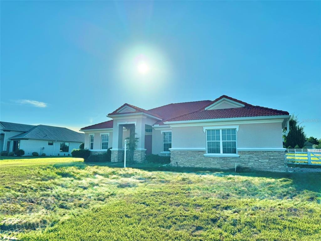 A single-story house with a tiled roof, stone veneer, and a front entryway — 56 S NEEDLES POINT, INVERNESS, FL