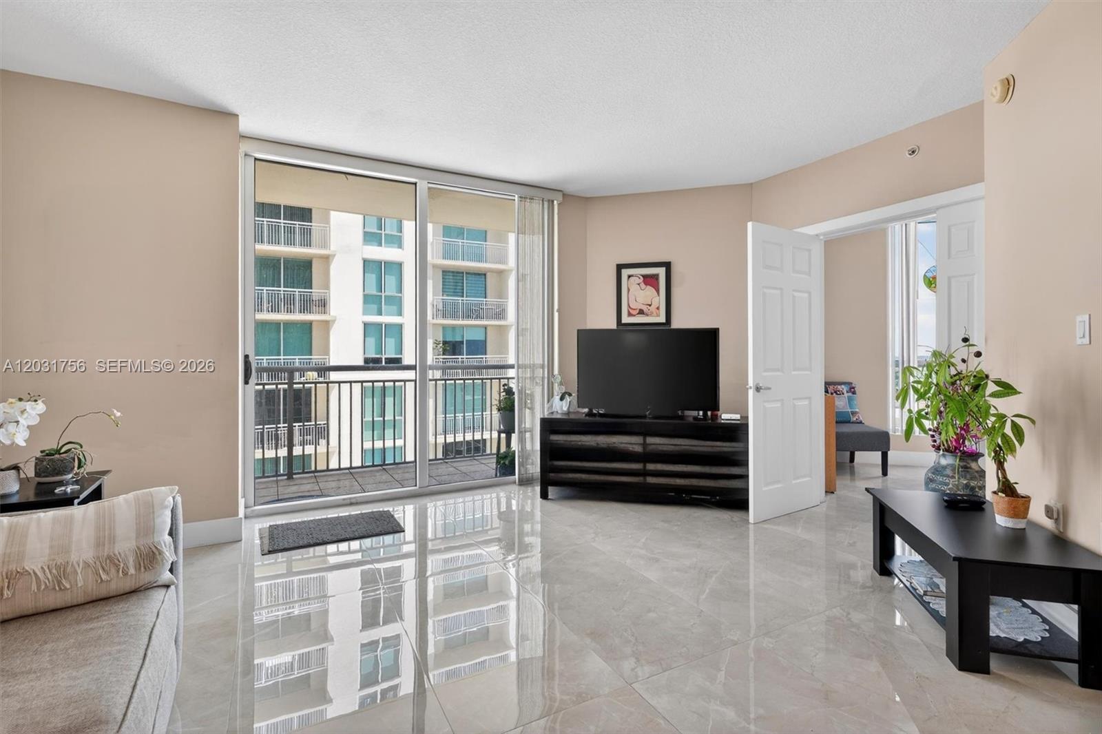 A living room with light tile floors, a television on a console, and a balcony — 9066 SW 73rd Ct # 1203, Miami FL 33156, MIAMI, FL