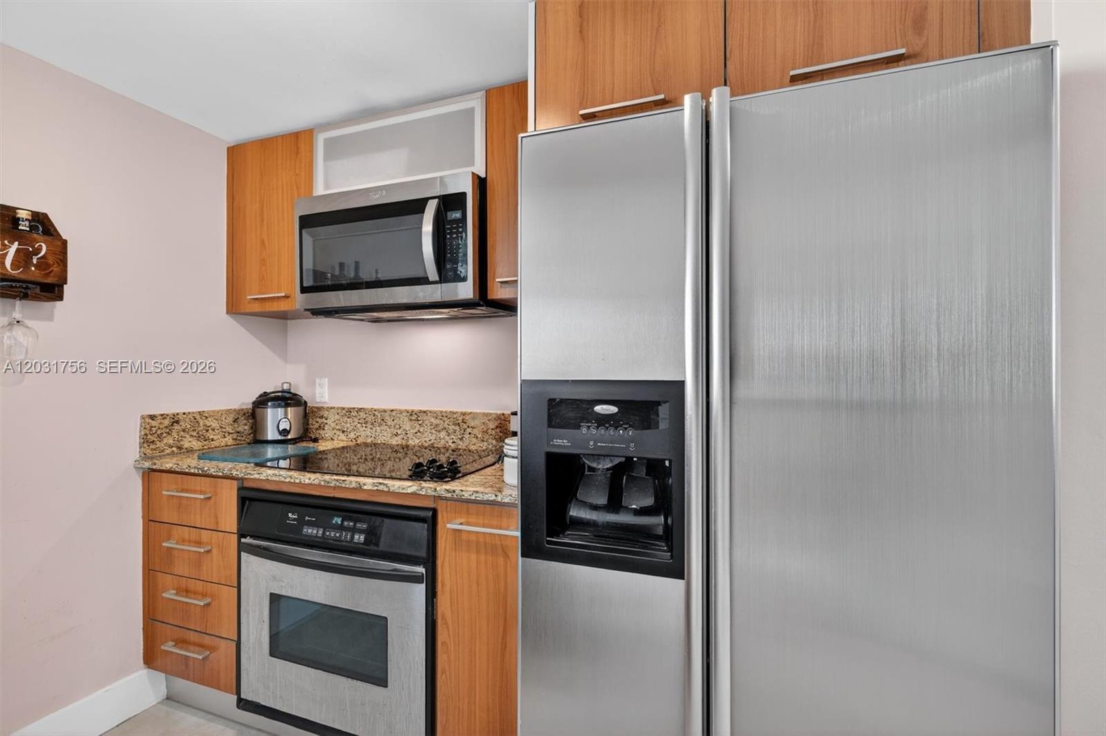 A kitchen features wood cabinets, stainless steel appliances, and granite countertops — 9066 SW 73rd Ct # 1203, Miami FL 33156, MIAMI, FL