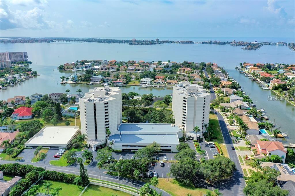 An aerial view shows two high-rise apartment buildings surrounded by residential homes and waterfront canals — 5950 PELICAN BAY PLAZA S UNIT 505, GULFPORT, FL
