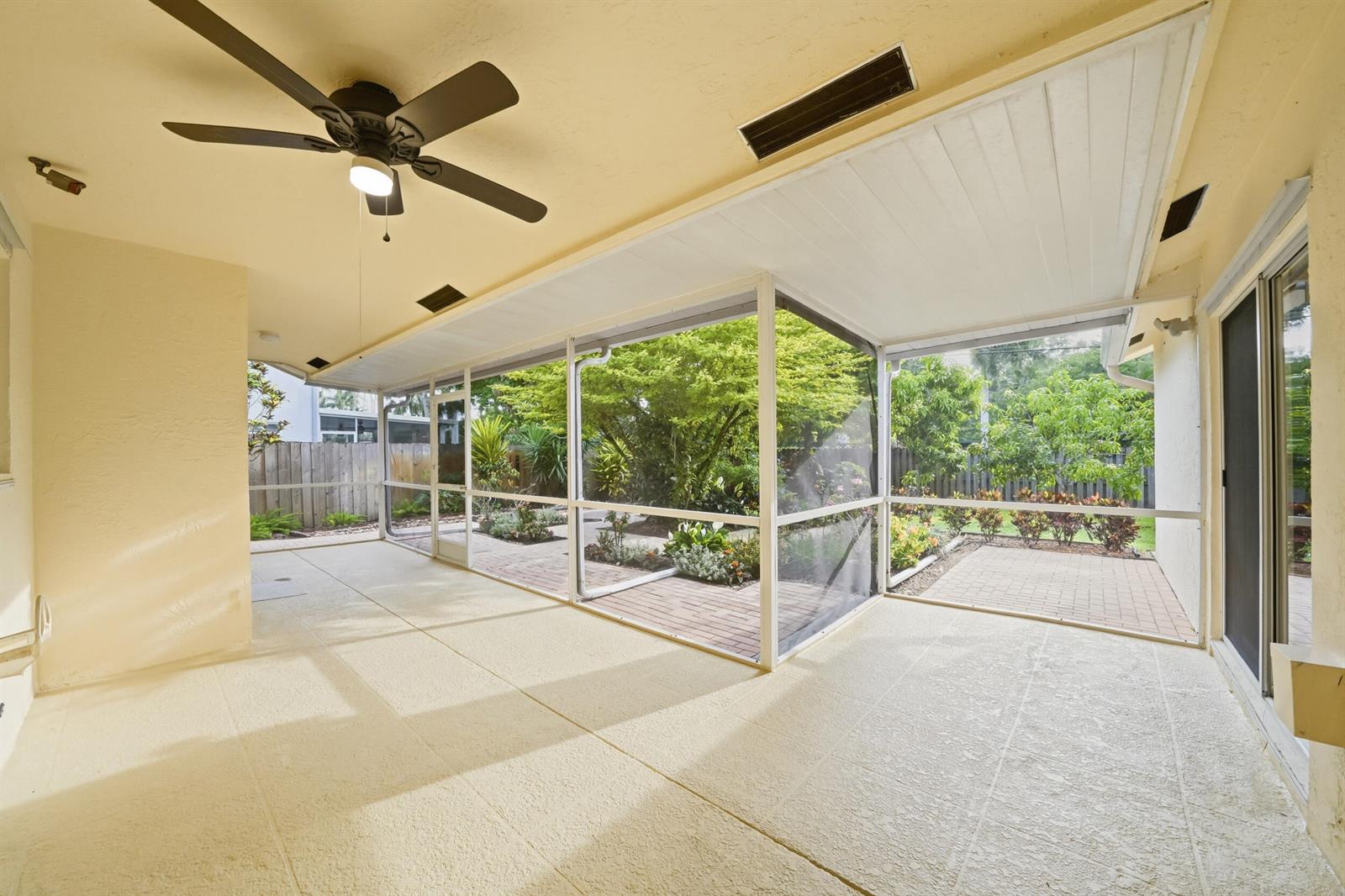 A covered, screened-in patio with a ceiling fan, concrete flooring, and a view of landscaping — 5787 SW 57th Way, Davie FL 33314, DAVIE, FL