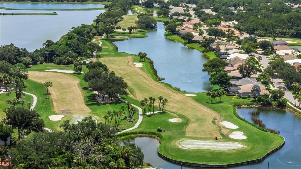 An aerial view shows several suburban houses with tiled roofs surrounded by trees and landscaping — 288 VENICE GOLF CLUB DRIVE, VENICE, FL