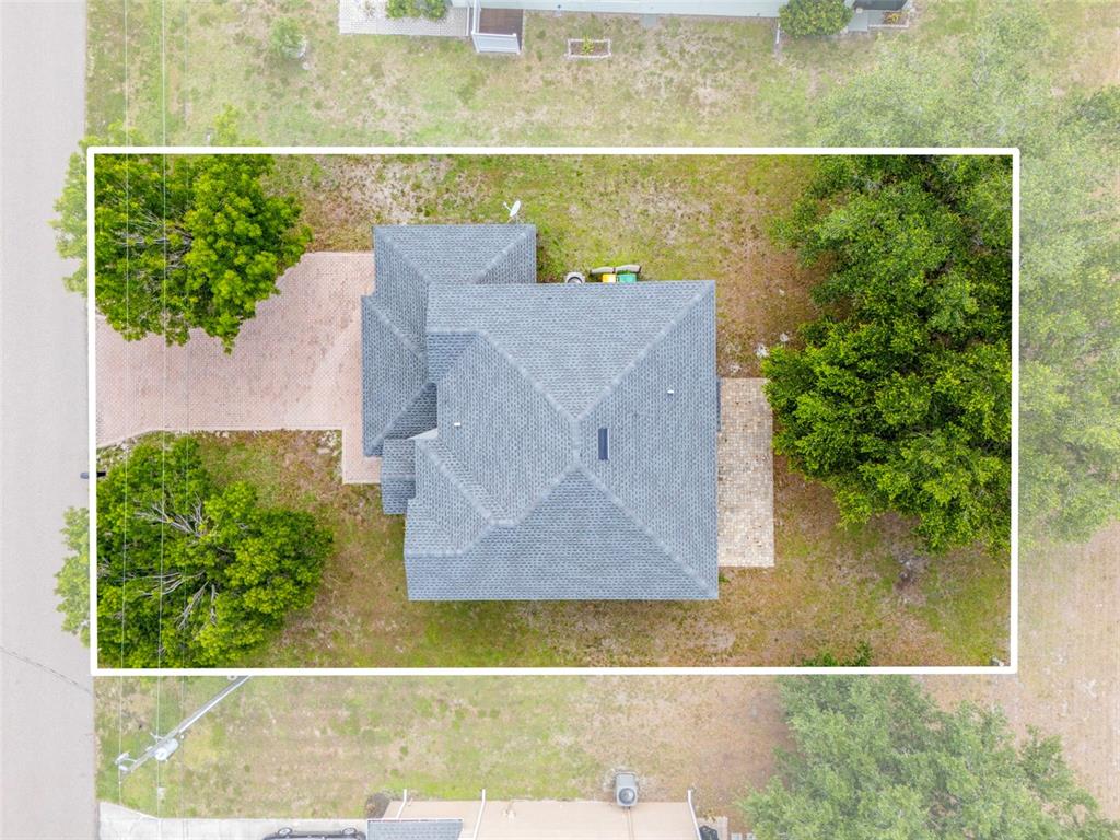 An aerial view shows a house with a gray shingled roof and a paved driveway — 25134 PALISADE ROAD, PUNTA GORDA, FL