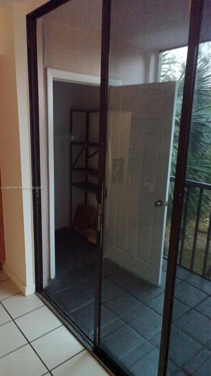 A view through a sliding glass door shows a small storage closet and a balcony — 8400 SW 133rd Ave Rd # 318, Miami FL 33183, MIAMI, FL