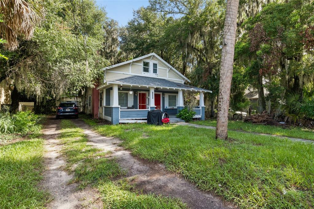 A small, beige concrete block outbuilding with a red door and an exterior AC unit — 1408 HIGH STREET UNIT C, LEESBURG, FL