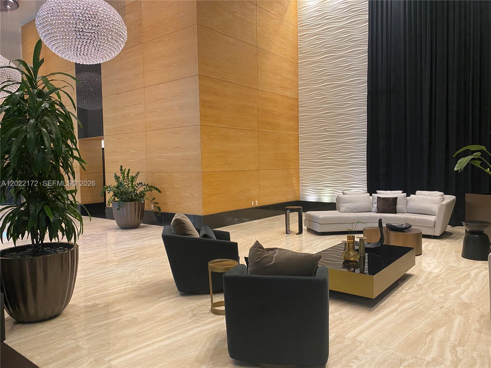 A modern lobby features wood-paneled walls, a textured accent wall, and contemporary lounge furniture — 950 Brickell Bay Dr # 2206, Miami FL 33131, MIAMI, FL