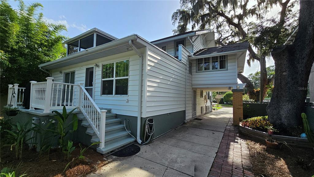 A two-story house with a brick-columned front porch and a large oak tree — 821 N EOLA DRIVE, ORLANDO, FL