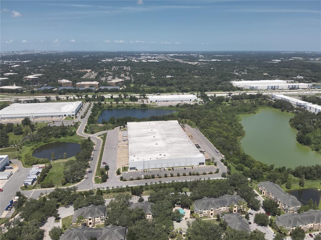 An aerial view shows a large industrial warehouse building surrounded by parking lots and ponds — 4605 WILLIAMS ROAD, TAMPA, FL