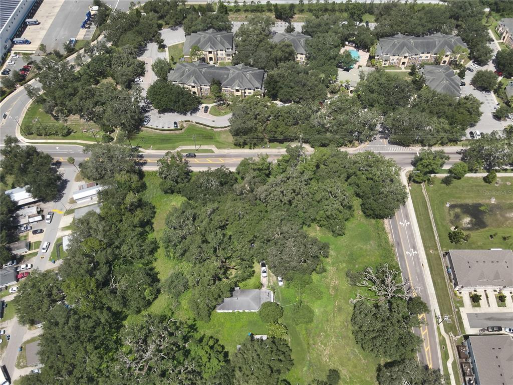 An aerial view shows a single-story house surrounded by trees and grass near a road — 4605 WILLIAMS ROAD, TAMPA, FL