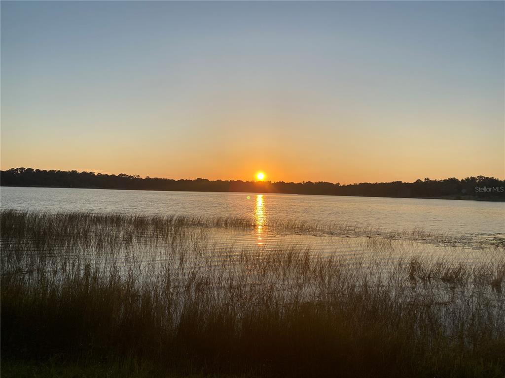 A sunset view over a lake with tall grasses in the foreground — TBD LOT 01000 SILVER DRIVE, UMATILLA, FL