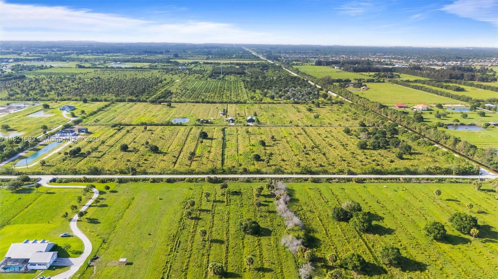An aerial view shows a large, flat, grassy rural landscape with scattered trees and buildings — 21st ST SW & 58th Ave, Vero Beach FL 32968, VERO BEACH, FL