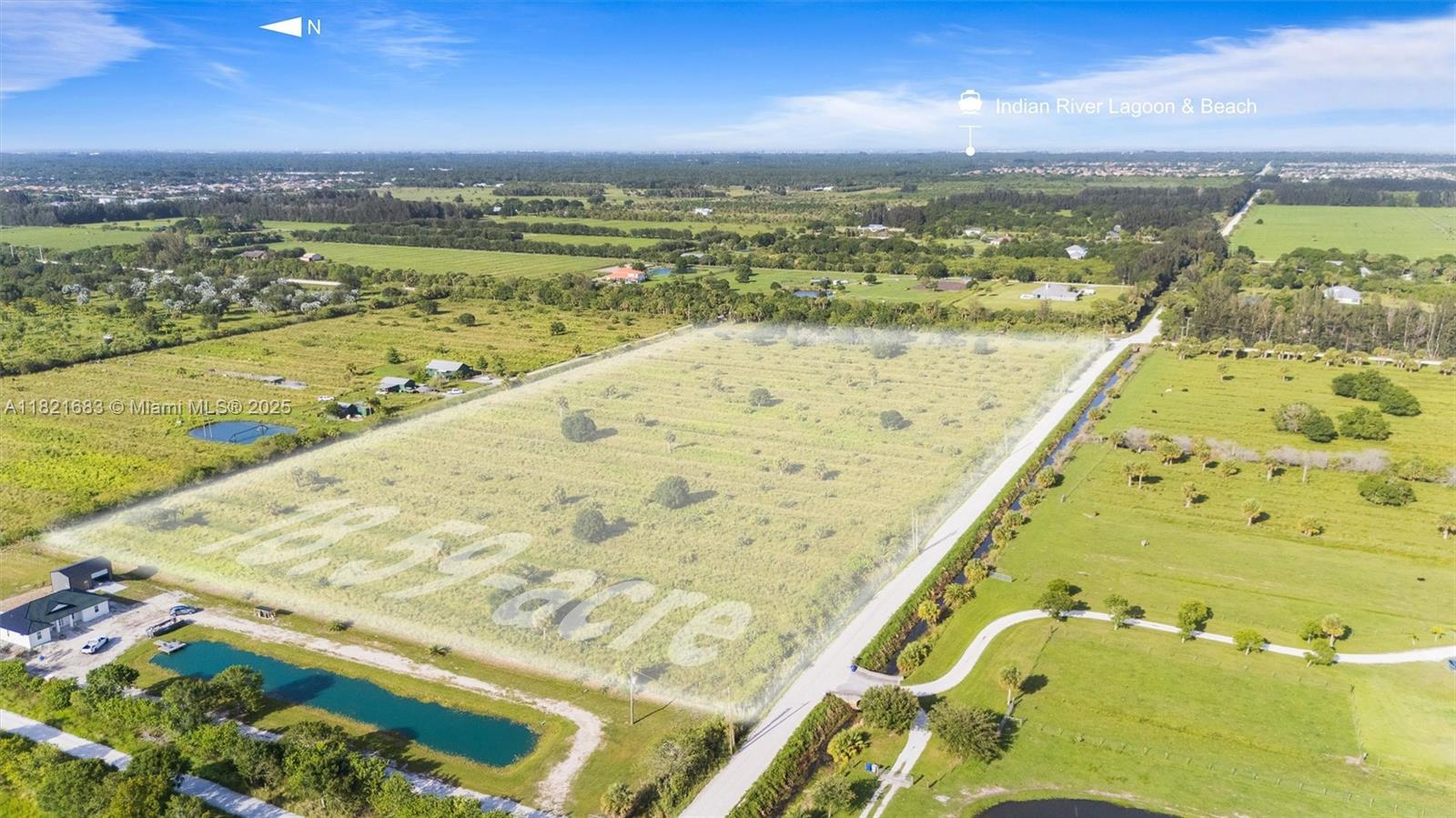 An aerial view shows a large, rectangular vacant lot bordered by a road and vegetation — 21st ST SW & 58th Ave, Vero Beach FL 32968, VERO BEACH, FL