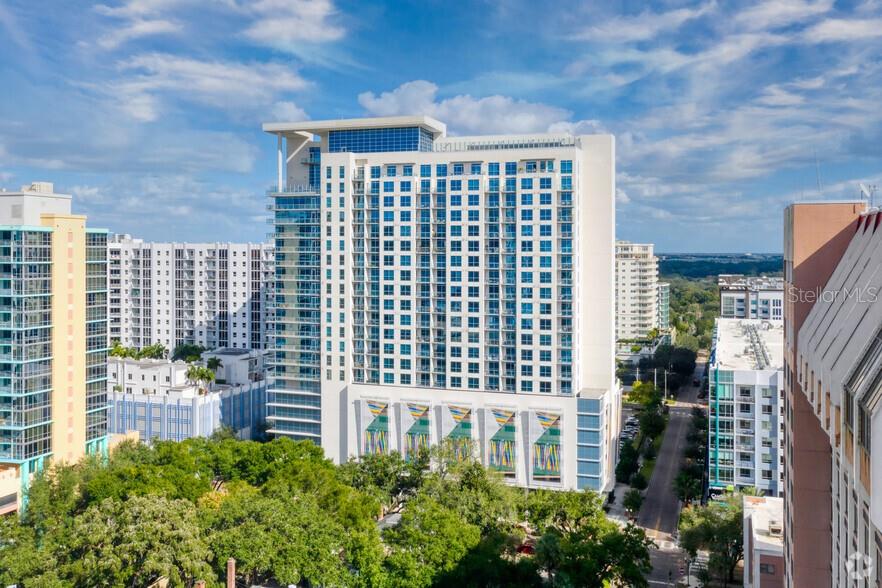 An exterior view of a tall, modern high-rise apartment building with blue glass windows — 101-1 LAKE AVENUE, ORLANDO, FL
