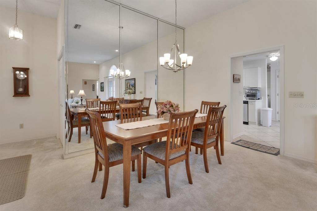 A dining room features a wooden table, six chairs, a chandelier, and a mirrored wall — 2520 S GLEN EAGLES DRIVE, DELAND, FL