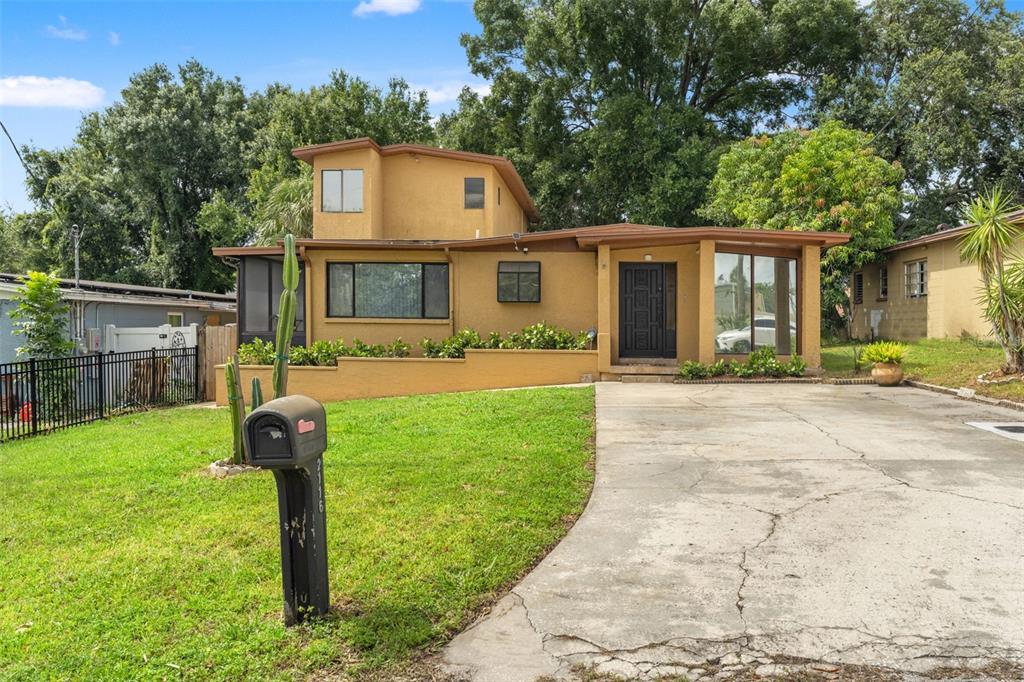 A two-story tan house with a concrete driveway, a front lawn, and a mailbox — 2116 W ABDELLA STREET, TAMPA, FL
