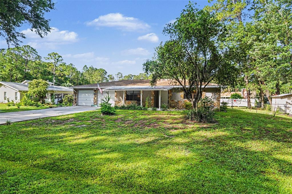 A single-story house with a stone facade, a two-car garage, and a large front lawn — 3740 S EASTPARK WAY, HOMOSASSA, FL