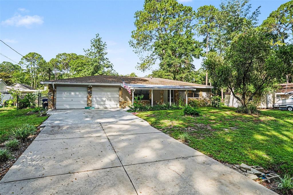 A single-story house with a two-car garage, stone accents, and a concrete driveway — 3740 S EASTPARK WAY, HOMOSASSA, FL
