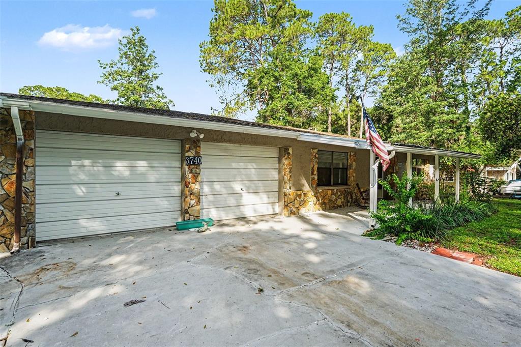 A single-story house with a two-car garage, stone accents, and a front porch — 3740 S EASTPARK WAY, HOMOSASSA, FL