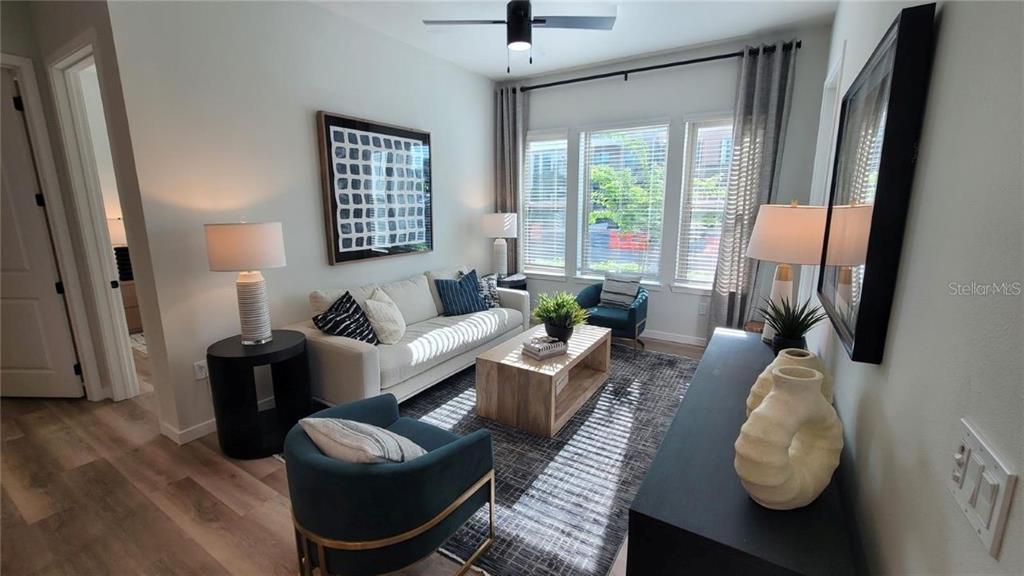 A living room features a sofa, two armchairs, a coffee table, and a ceiling fan — 10215 ESTUARY LAKES DRIVE UNIT 220, TAMPA, FL