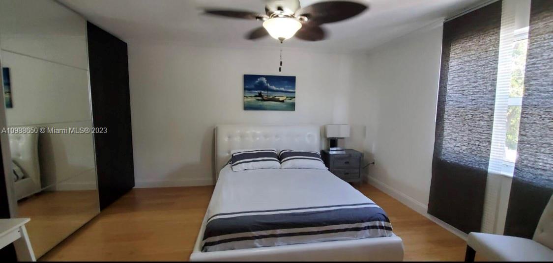 A bedroom features a white bed, a mirrored closet, and a ceiling fan — 753 Michigan # 2B, Miami Beach FL 33139, MIAMI BEACH, FL