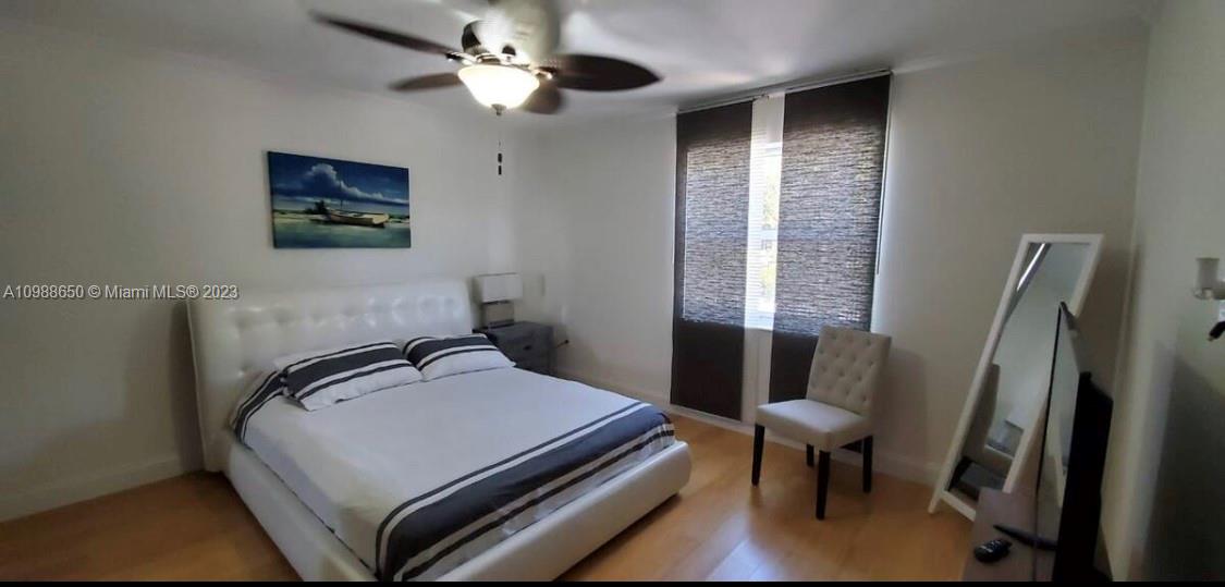 A bedroom features a white bed, a ceiling fan, a chair, and a floor mirror — 753 Michigan # 2B, Miami Beach FL 33139, MIAMI BEACH, FL