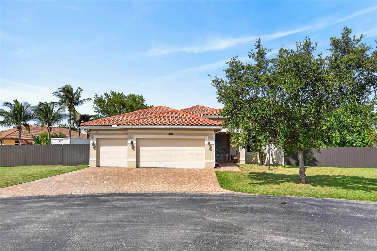 A single-story house with a tile roof, three-car garage, and a paved driveway — 2135 NW 14th Ter, Homestead FL 33030, HOMESTEAD, FL