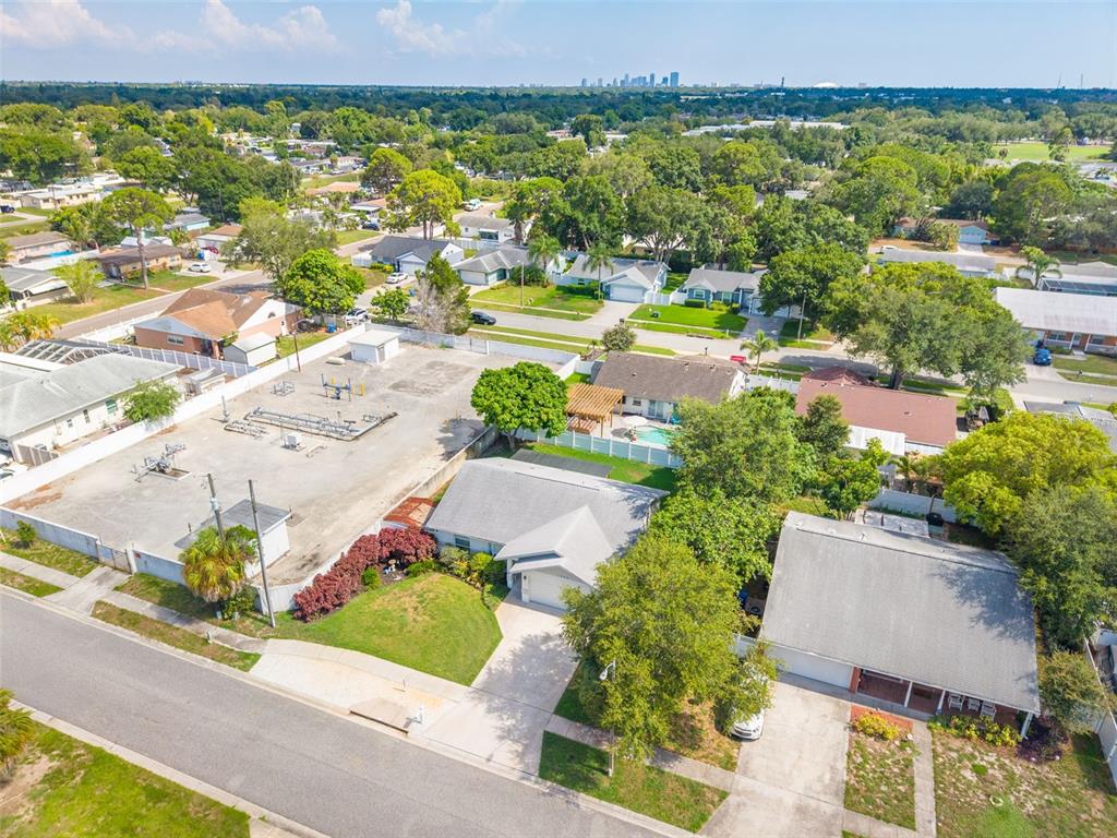 A living room features light gray walls, wood-look flooring, a ceiling fan, and gray furniture — 1848 77TH AVENUE N, ST PETERSBURG, FL