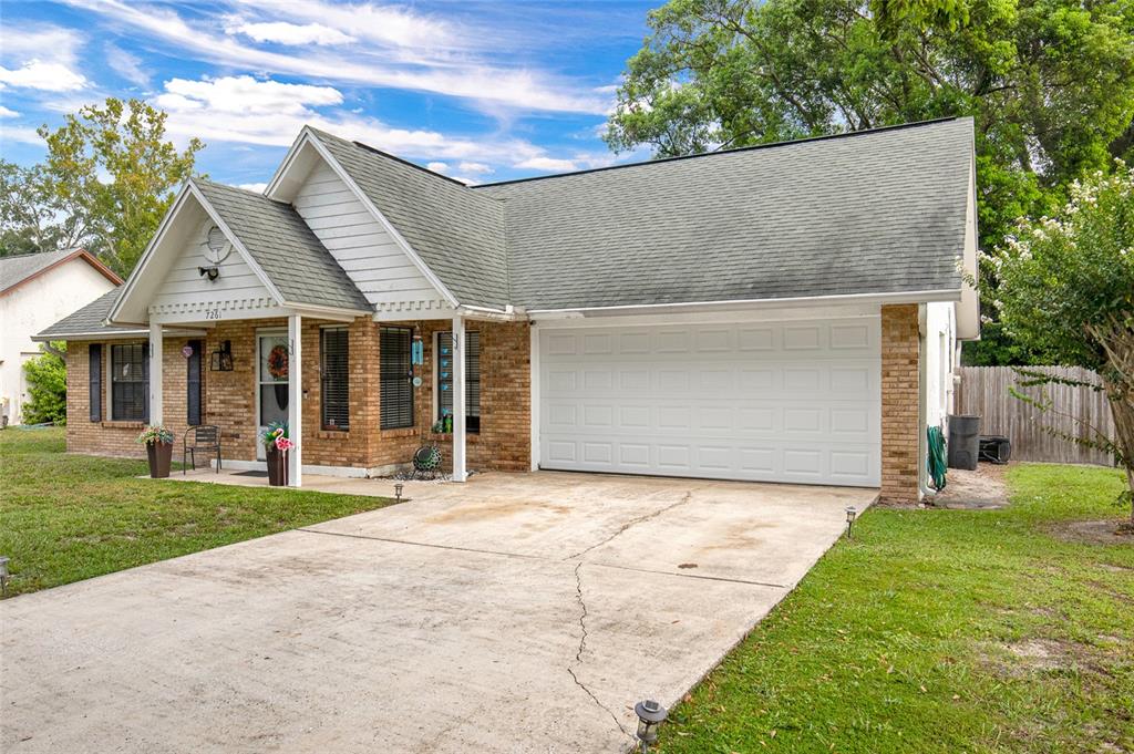 A single-story brick house with a front-facing two-car garage and a concrete driveway — 7261 ABBEY LANE, WINTER PARK, FL