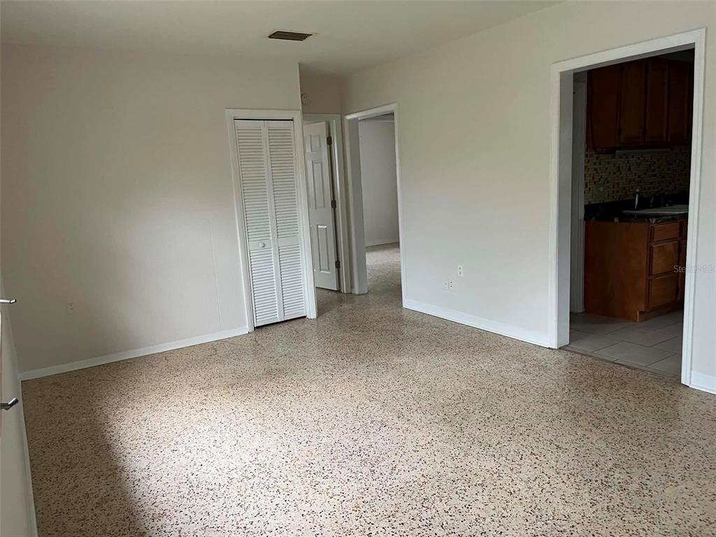A room with light-colored walls, a speckled terrazzo floor, and two doorways leading to other areas — 6445 RIVER ROAD, NEW PORT RICHEY, FL