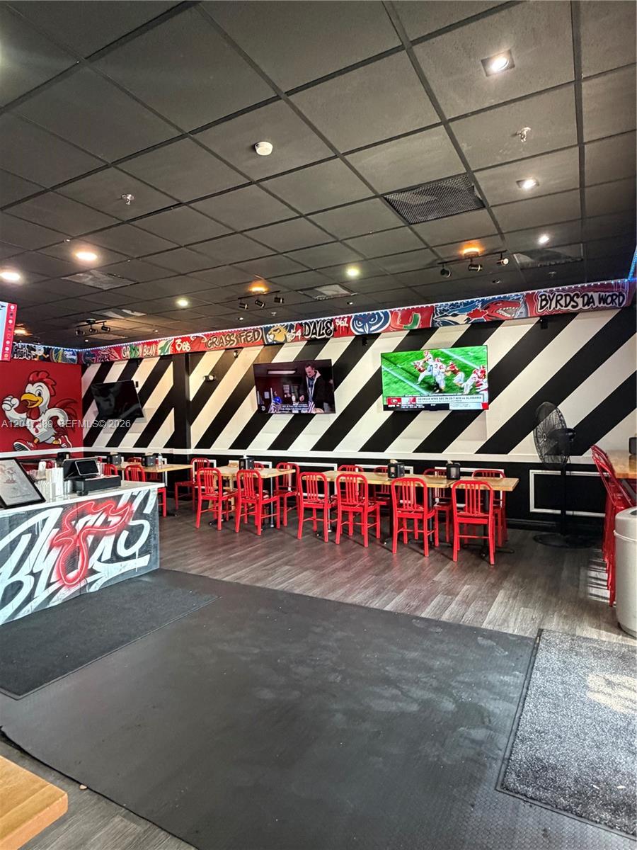 A restaurant interior features black and white striped walls, red chairs, and multiple wall-mounted televisions — 1313 W Boynton Beach Blvd, Boynton Beach FL 33426, BOYNTON BEACH, FL