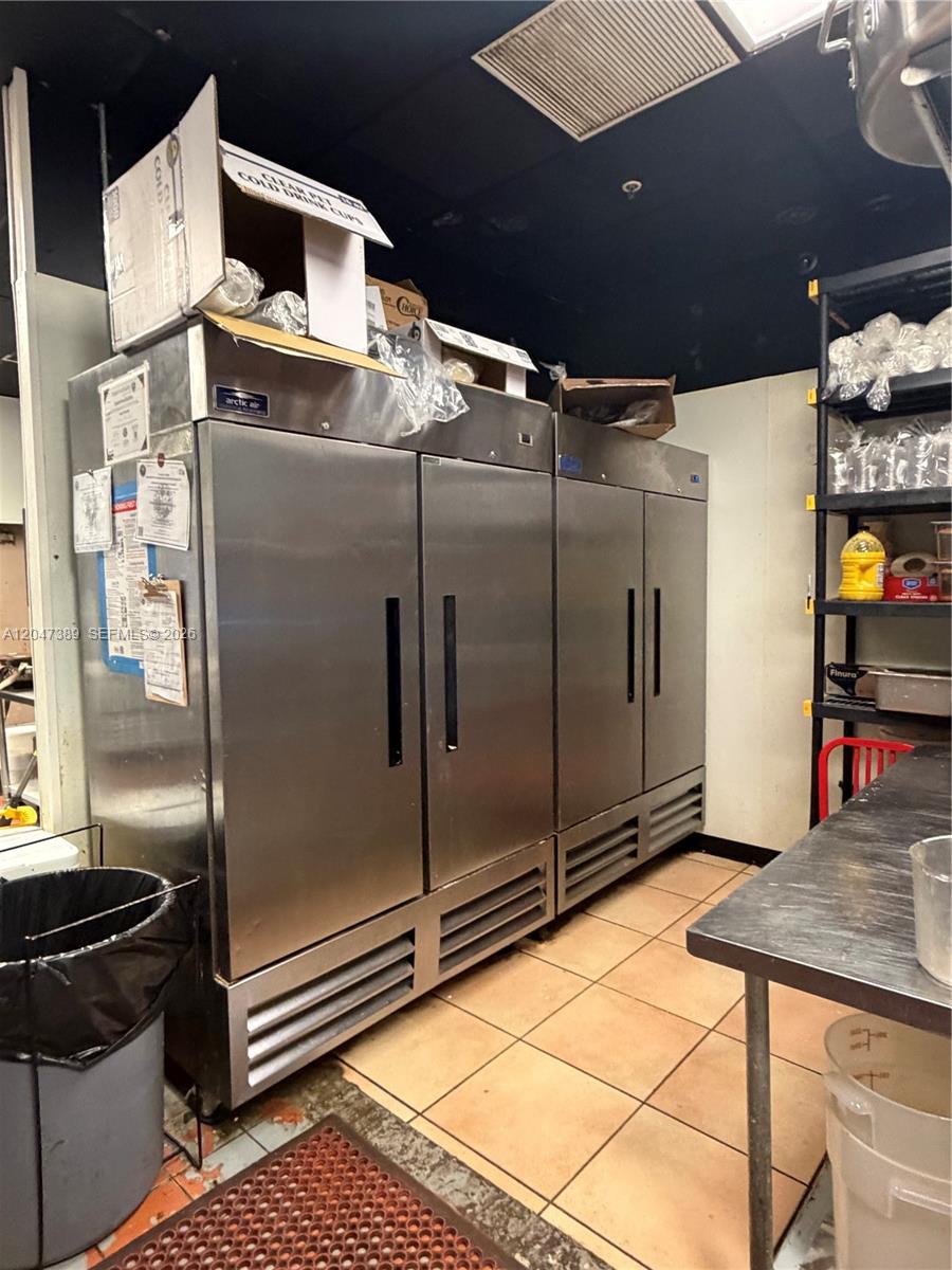 A commercial kitchen features two stainless steel refrigerators, a metal prep table, and shelving — 1313 W Boynton Beach Blvd, Boynton Beach FL 33426, BOYNTON BEACH, FL