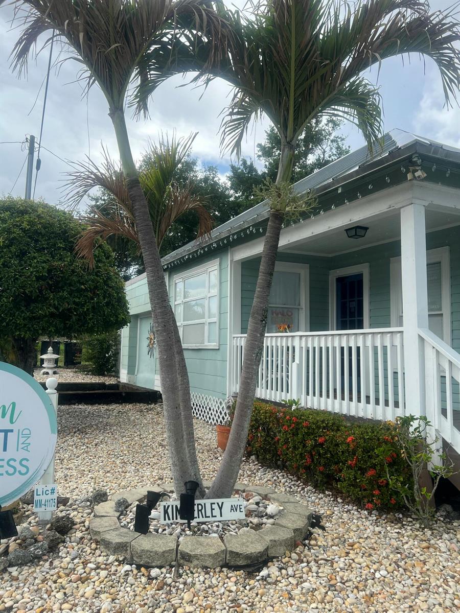 A light green house with a white porch and two palm trees in the front yard — 208 Avenue E, Fort Pierce FL 34950, FORT PIERCE, FL