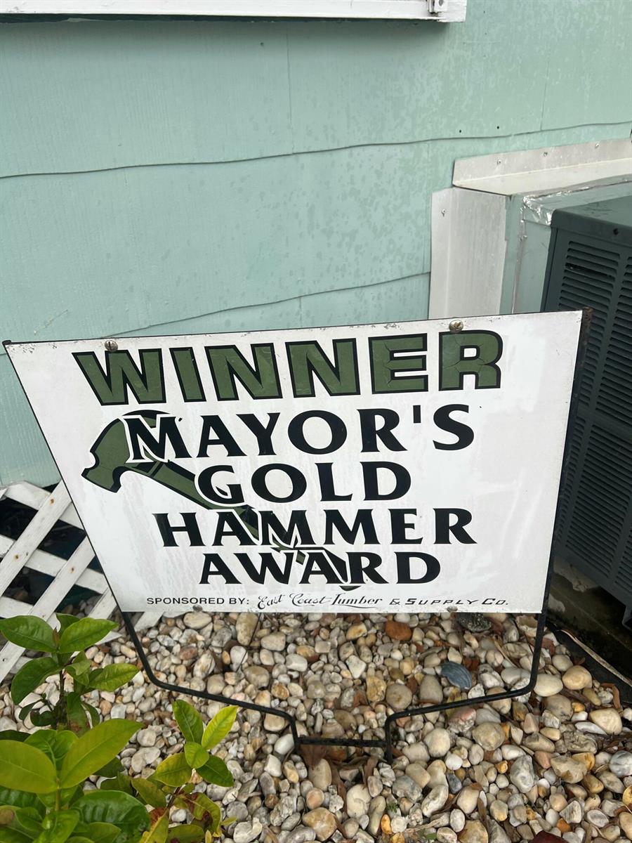 A sign for the Mayor's Gold Hammer Award sits on a bed of landscaping rocks — 208 Avenue E, Fort Pierce FL 34950, FORT PIERCE, FL
