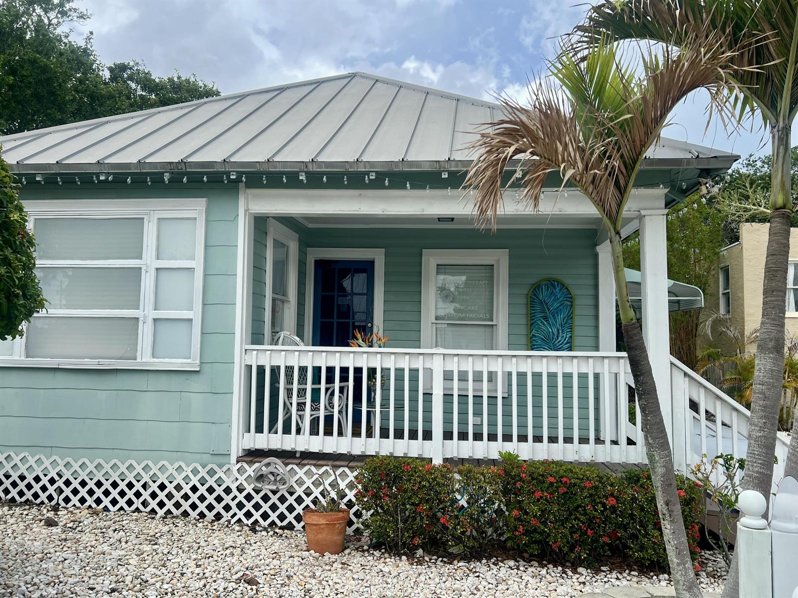 A light green house with a metal roof, white porch railing, and a palm tree — 208 Avenue E, Fort Pierce FL 34950, FORT PIERCE, FL