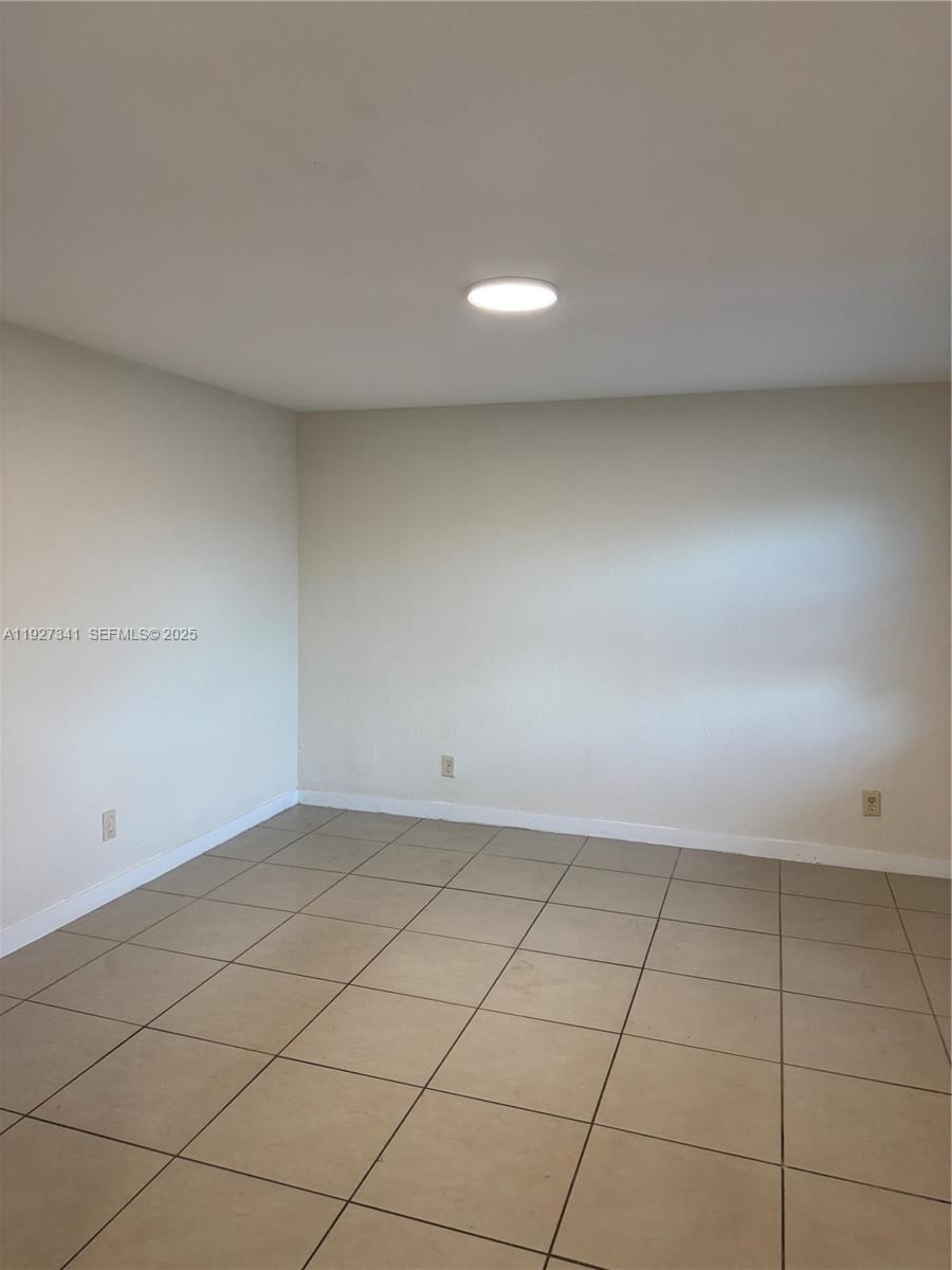 An empty room features light-colored walls, a single ceiling light, and tan floor tiles — 4717 SW 33rd Ave # 202, Dania Beach FL 33312, DANIA BEACH, FL