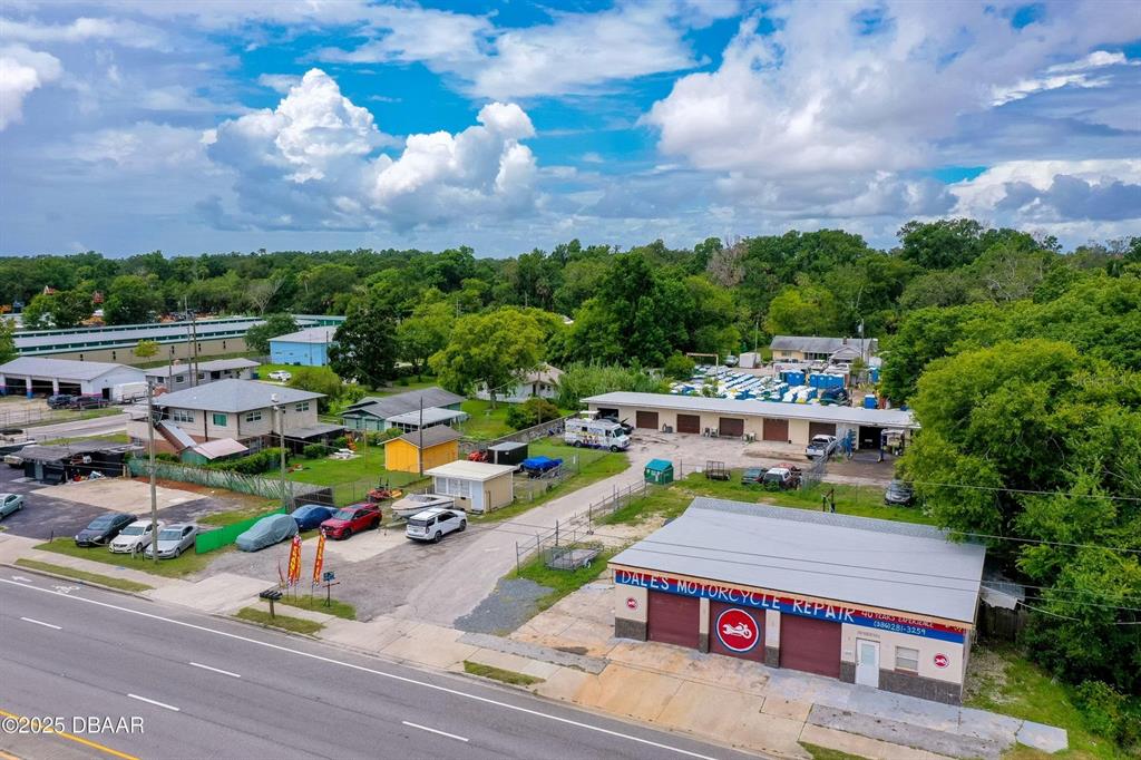 An aerial view shows a motorcycle repair shop with a parking lot and surrounding buildings — 1520 N NOVA & 10TH ROAD, DAYTONA BEACH, FL
